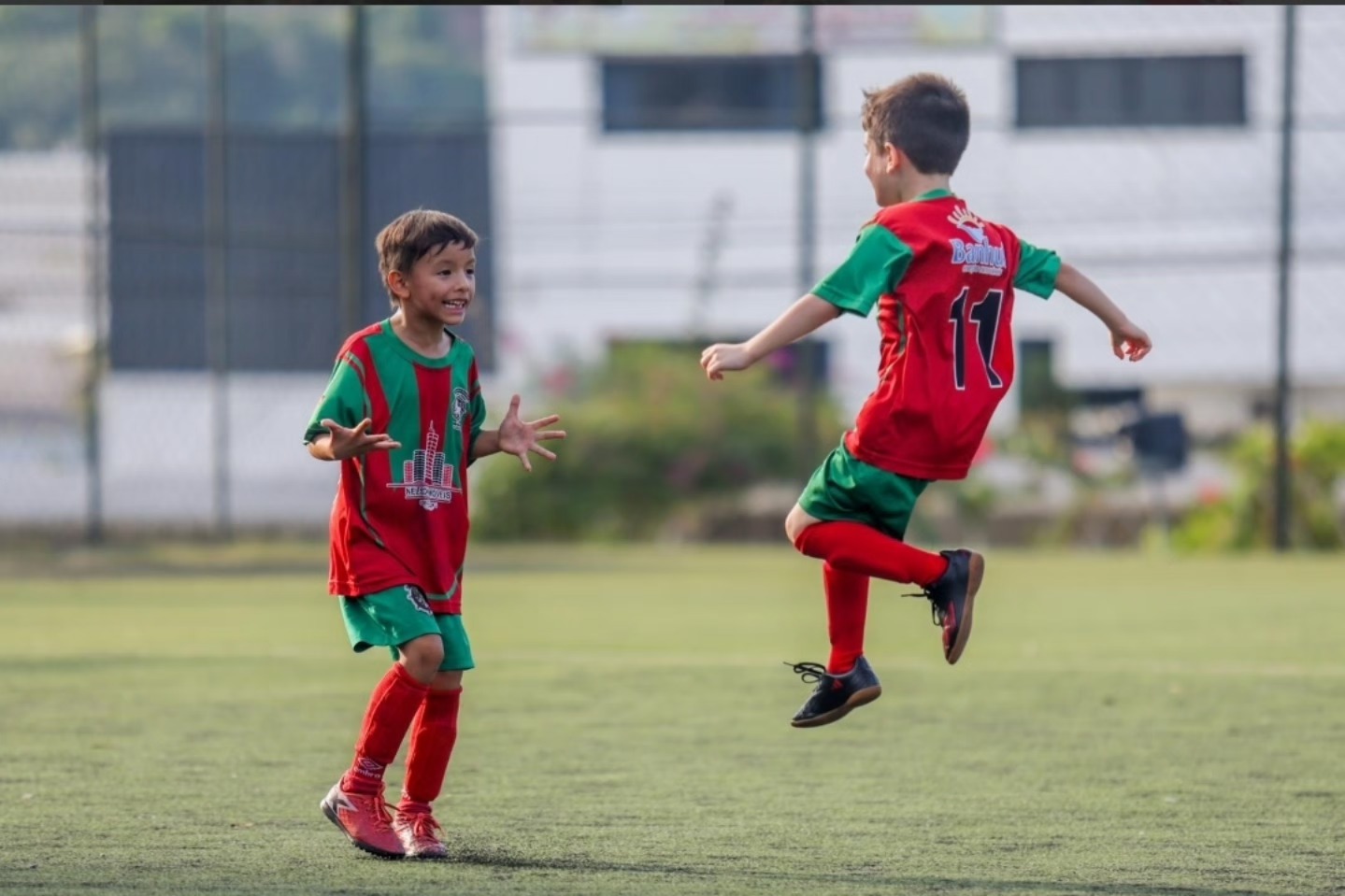 Dois alunos pequenos comemorando juntos durante a partida