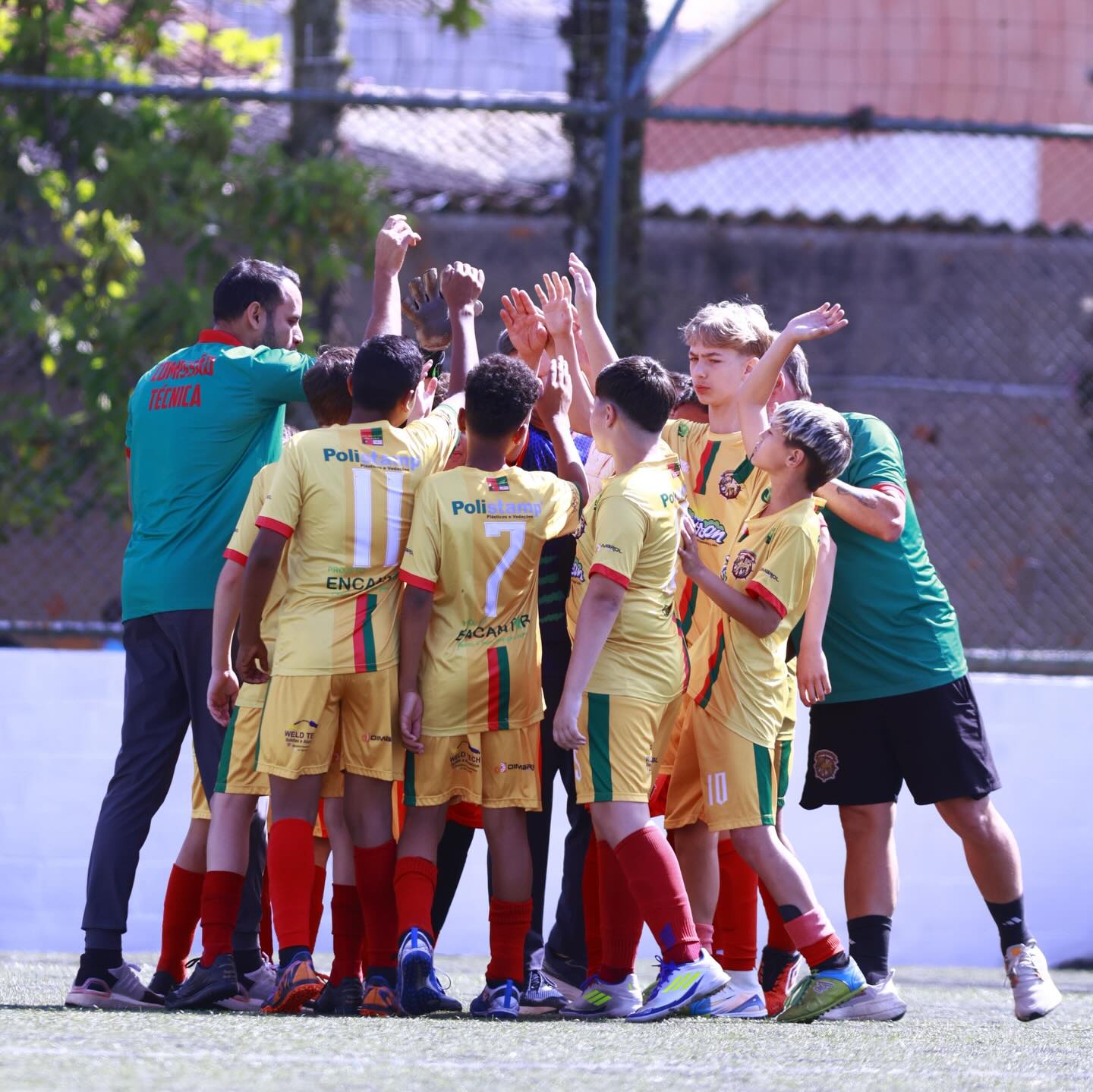 Alunos e comissão técnica reunidos em roda antes do jogo